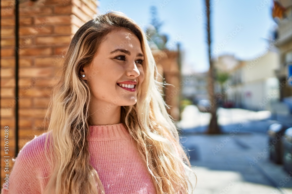 Young blonde woman smiling at the city Young blonde woman smiling at the city