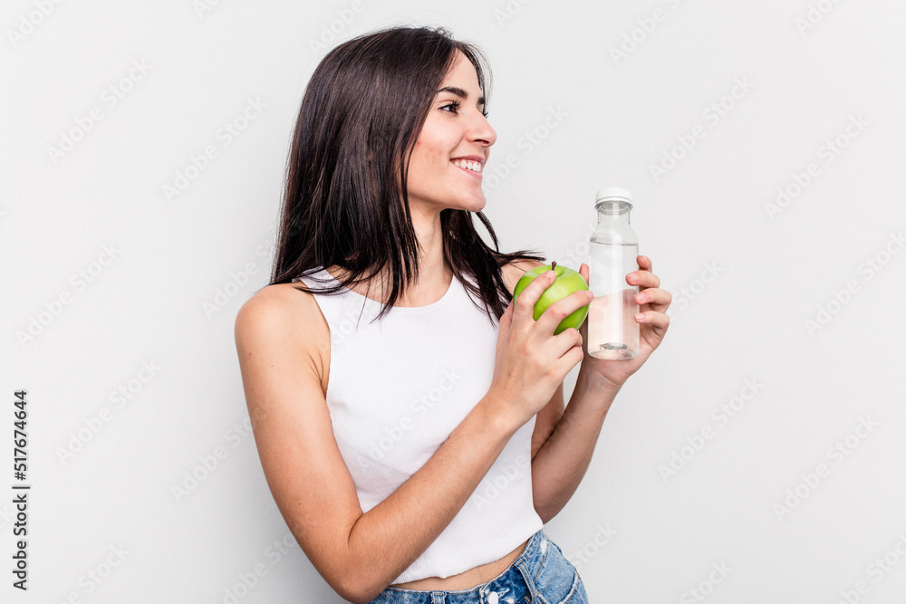 Young caucasian woman holding apple and bottle of water isolated on white background Young caucasian woman holding apple and bottle of water isolated on white background