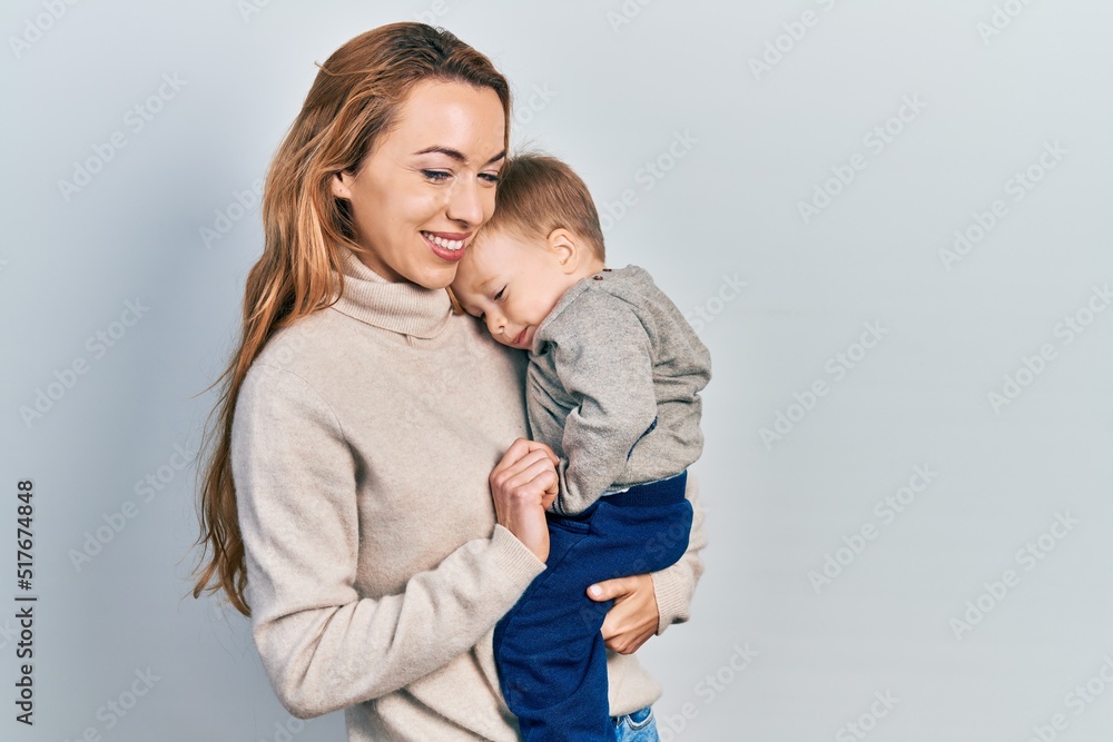 Young caucasian woman holding and hugging her son with love. Family of two bonding together. Mother holding infant toddler Young caucasian woman holding and hugging her son with love. Family of two bonding together. Mother holding infant toddler