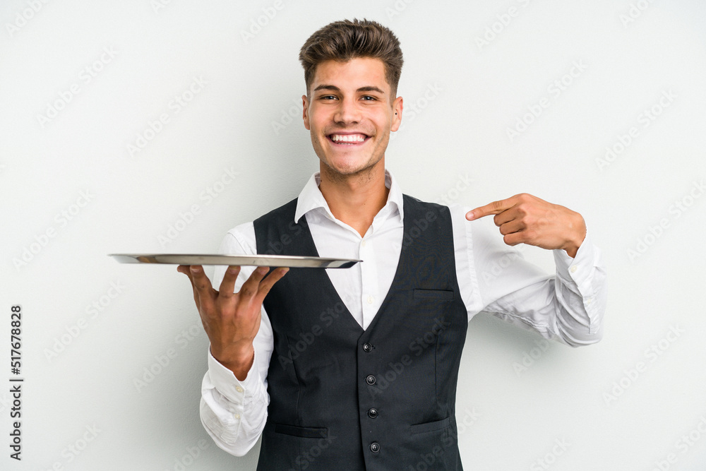 Young caucasian waitress man holding a tray isolated on white background person pointing by hand to a shirt copy space, proud and confident Young caucasian waitress man holding a tray isolated on white background person pointing by hand to a shirt copy space, proud and confident