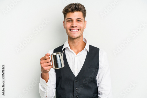 Young caucasian barista man isolated on yellow background happy, smiling and cheerful. © Asier