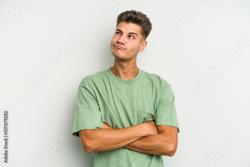 Young caucasian man isolated on white background dreaming of achieving goals and purposes