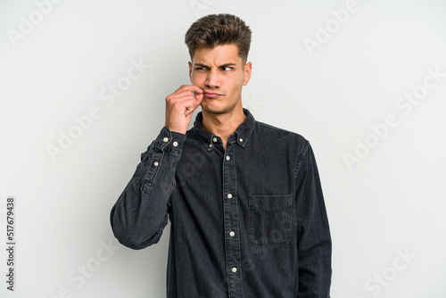 Young caucasian man isolated on white background with fingers on lips keeping a secret.