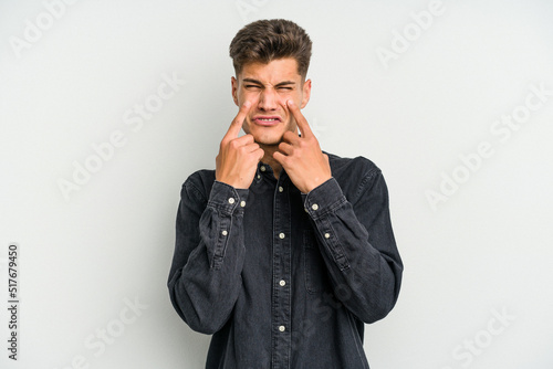 Young caucasian man isolated on white background crying, unhappy with something, agony and confusion concept. © Asier