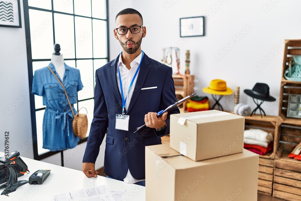 African american man working as manager at retail boutique making fish face with lips, crazy and comical gesture. funny expression. African american man working as manager at retail boutique making fish face with lips, crazy and comical gesture. funny expression.