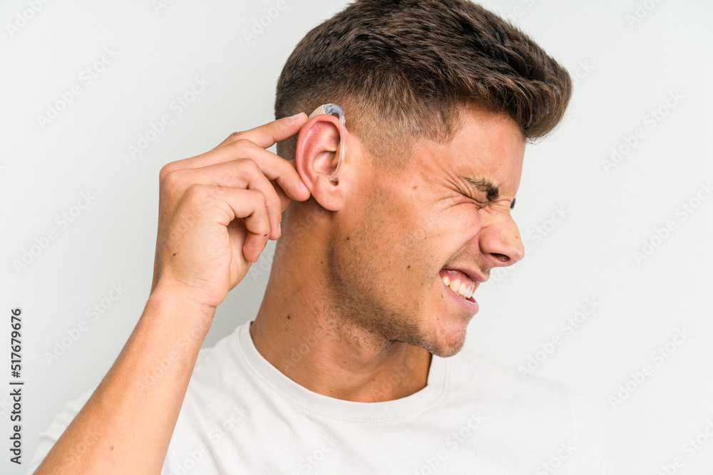 Young caucasian man wearing a hearing aid isolated on white background Young caucasian man wearing a hearing aid isolated on white background