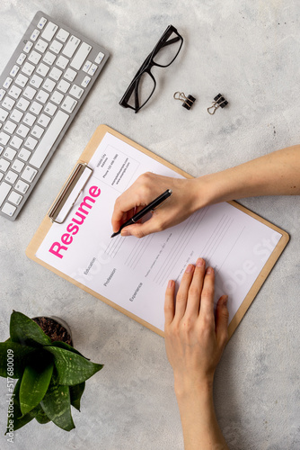 Фотография Job seeker filling resume application form on office table