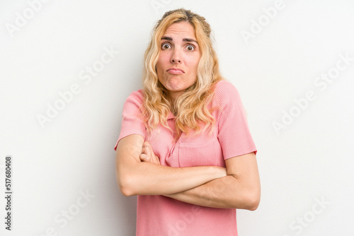 Young caucasian woman isolated on white background shrugs shoulders and open eyes confused.
