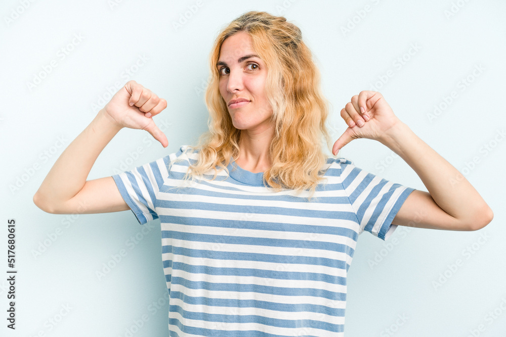 Young caucasian woman isolated on blue background feels proud and self confident, example to follow. Young caucasian woman isolated on blue background feels proud and self confident, example to follow.