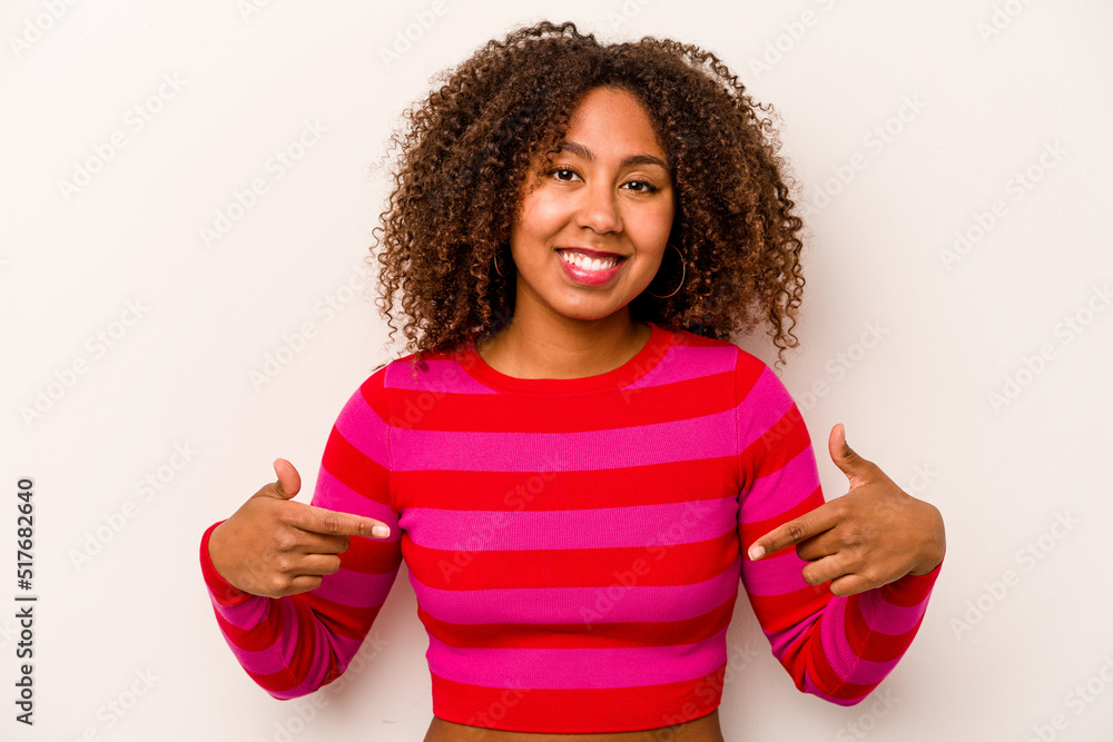 Young African American woman isolated on white background points down with fingers, positive feeling. Young African American woman isolated on white background points down with fingers, positive feeling.