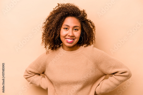 Young African American woman isolated on beige background happy, smiling and cheerful. © Asier