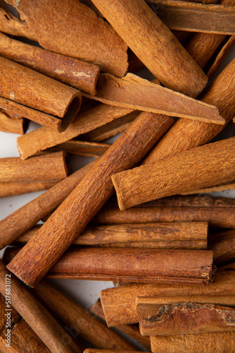 Food spice background with cinnamon sticks on light surface top view