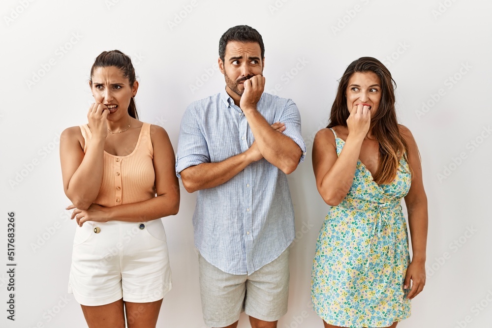 Group of young hispanic people standing over isolated background looking stressed and nervous with hands on mouth biting nails. anxiety problem. Group of young hispanic people standing over isolated background looking stressed and nervous with hands on mouth biting nails. anxiety problem.