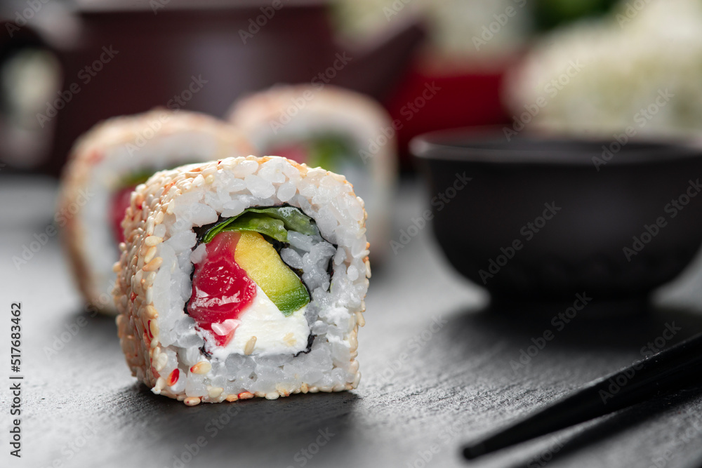 Roll with fish sushi with chopsticks. Philadelphia Roll . Japanese kitchen, restaurant. Roll with fish sushi with chopsticks. Philadelphia Roll . Japanese kitchen, restaurant.