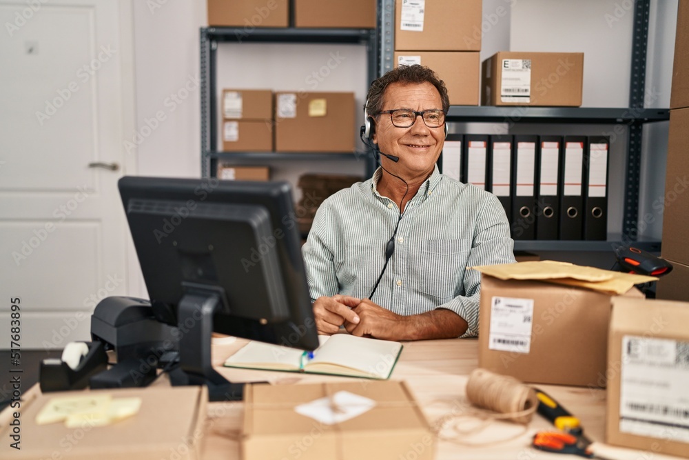 Senior man working at small business ecommerce wearing headset looking to side, relax profile pose with natural face and confident smile. Senior man working at small business ecommerce wearing headset looking to side, relax profile pose with natural face and confident smile.