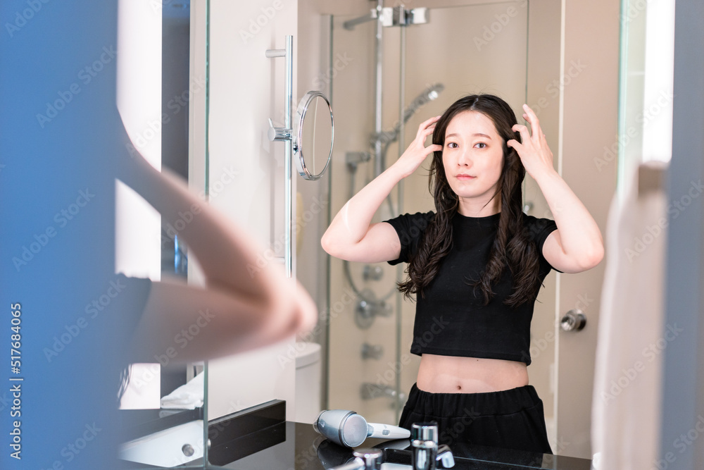 ドライヤーで髪を乾かす若い女性 ドライヤーで髪を乾かす若い女性