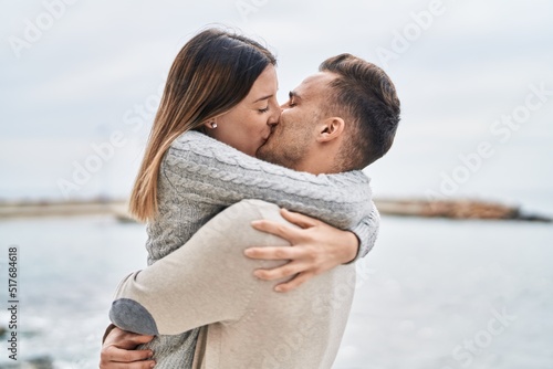 Fotografiet Man and woman couple hugging each other kissing at seaside