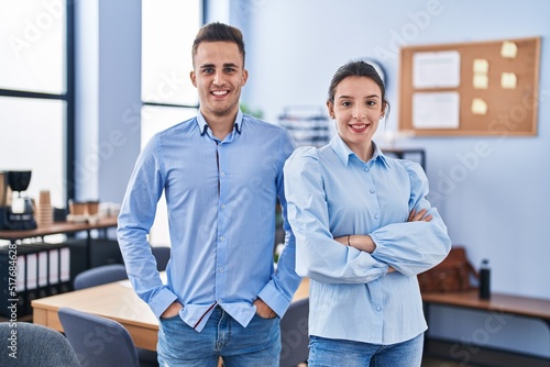 Man and woman business workers smiling confident standing with arms crossed gesture at office