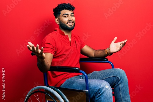 Arab man with beard sitting on wheelchair smiling showing both hands open palms, presenting and advertising comparison and balance