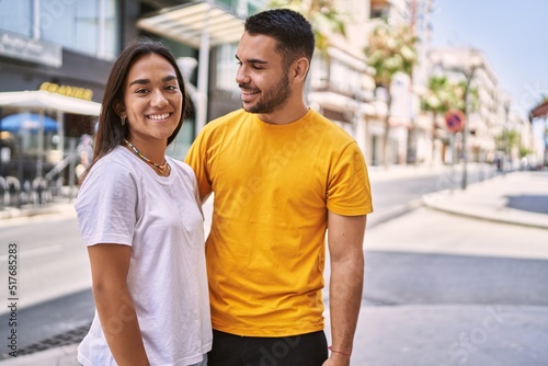 Young latin couple smiling happy and hugging standing at the city.