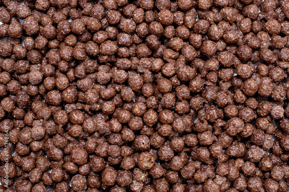 Background of round chocolate flakes in the form of balls. The concept of fast carbohydrate breakfast. Free space for text and advertising. American style chocolate balls background Background of round chocolate flakes in the form of balls. The concept of fast carbohydrate breakfast. Free space for text and advertising. American style chocolate balls background