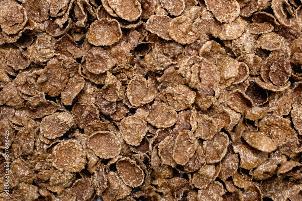 Background of brown sweet cereals with free space for text. The concept of a fast carbohydrate energy breakfast or meal. Flakes from durum wheat and cereals. Healthy American style breakfast Background of brown sweet cereals with free space for text. The concept of a fast carbohydrate energy breakfast or meal. Flakes from durum wheat and cereals. Healthy American style breakfast
