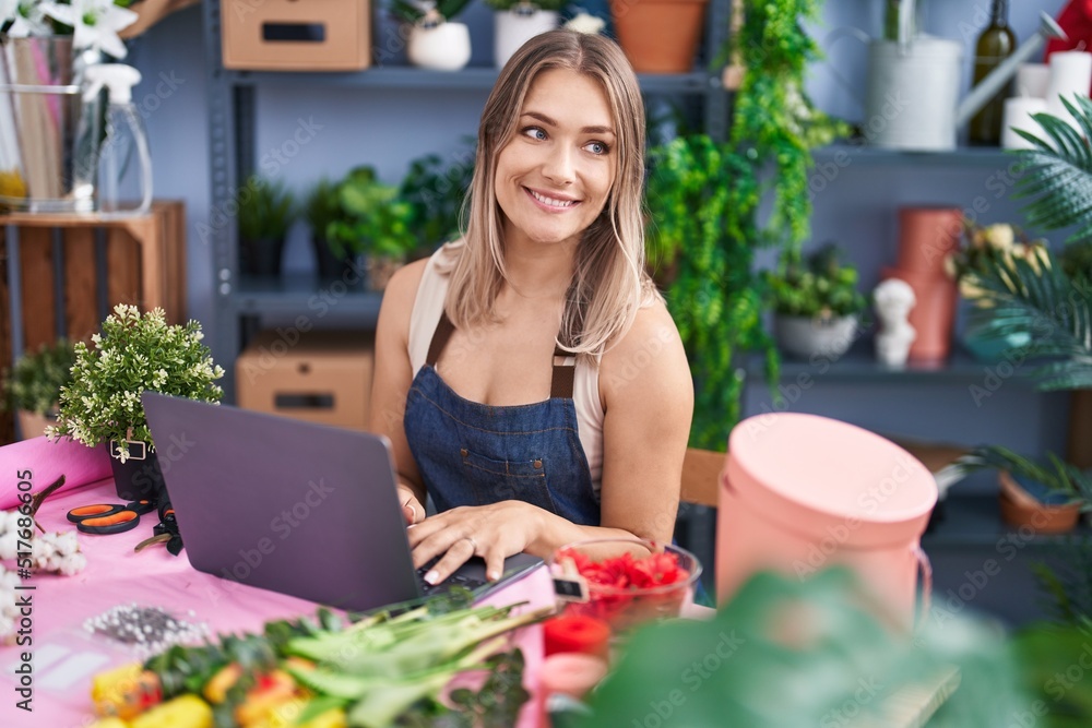 Young caucasian woman florist smiling confident using laptop at florist