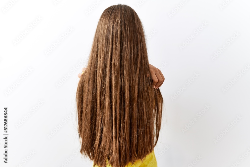 Naklejka premium Young brunette teenager standing together over isolated background hugging oneself happy and positive from backwards. self love and self care