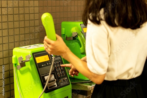 Fotografie 公衆電話で電話をかける女性