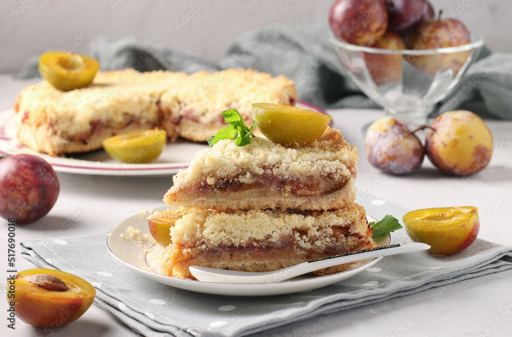 Homemade shortbread plum pie with cut pieces on plate on light gray background, Closeup Homemade shortbread plum pie with cut pieces on plate on light gray background, Closeup