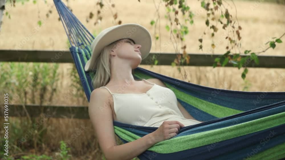 Tired mother tries to sleep in hammock in garden Tired mother tries to sleep in hammock in garden
