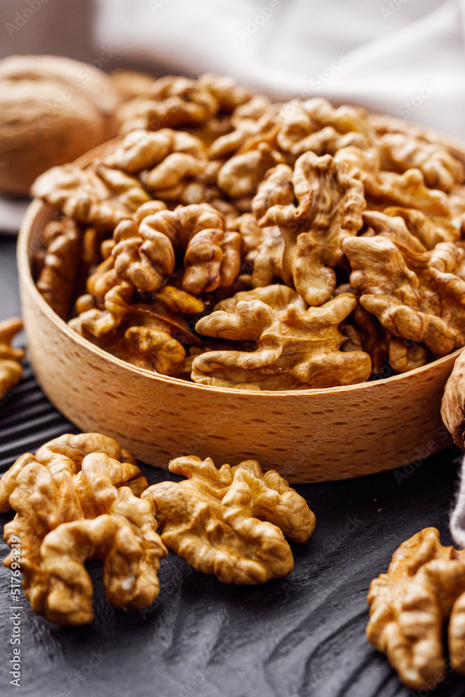 dried walnuts on a black rustic wooden background dried walnuts on a black rustic wooden background