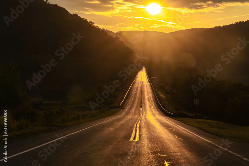 Summer road trip with setting sun in mountain scenery 
