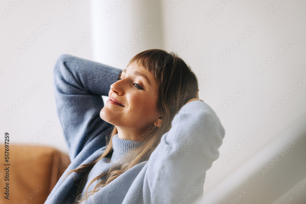 Pensive businesswoman relaxing with her hands behind her head