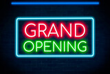 Grand Opening neon banner light signboard on brick wall background.	