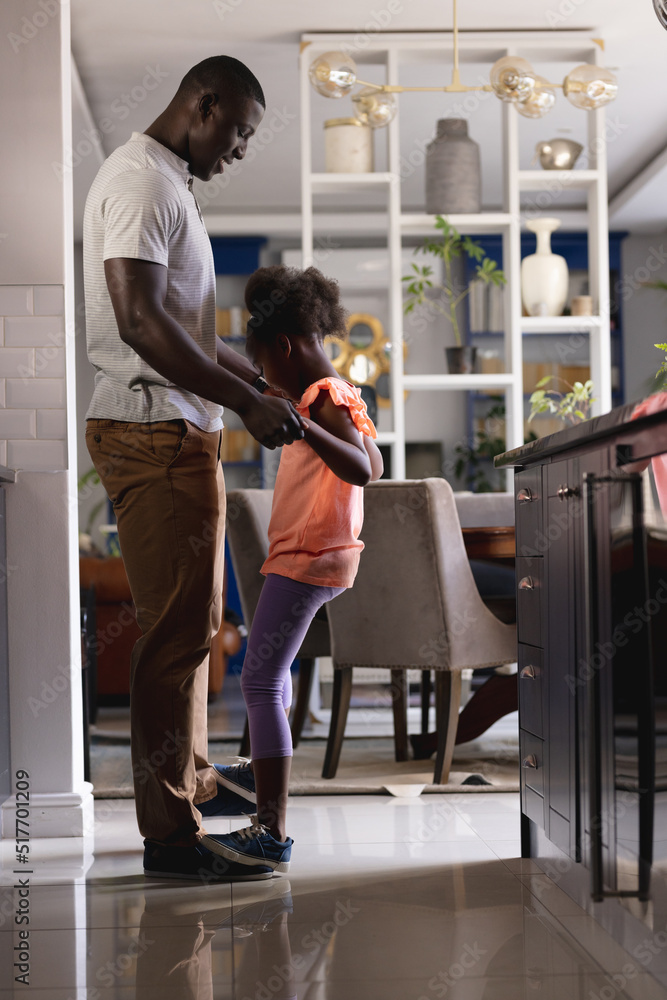 Vertical image of african american father and daughter dancing in kitchen Vertical image of african american father and daughter dancing in kitchen