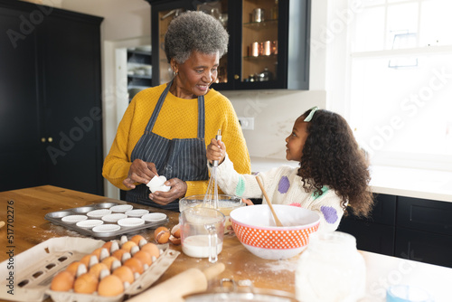 Принти на полотні Image of happy african american grandmother and granddaughter baking in kitchen