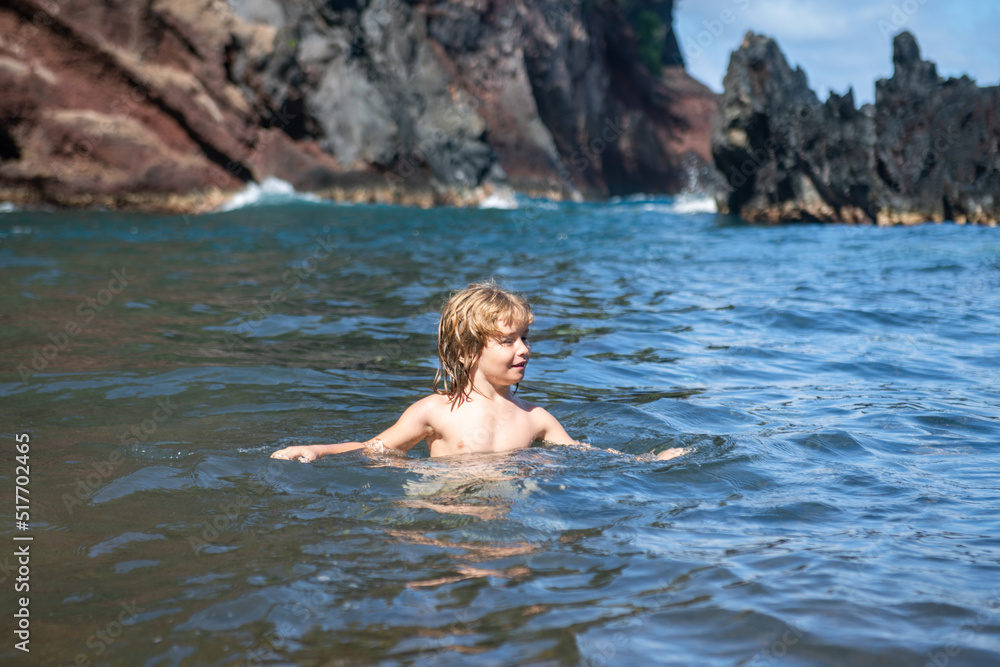 Little boy swimming in the sea. Kid on a tropical beach. Summer kids vacation.