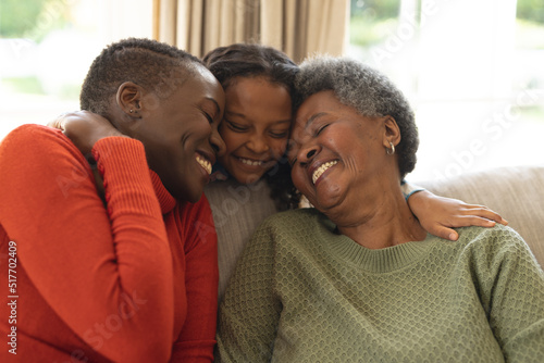 Photography Image of happy african american three generation women sitting on sofa and embra