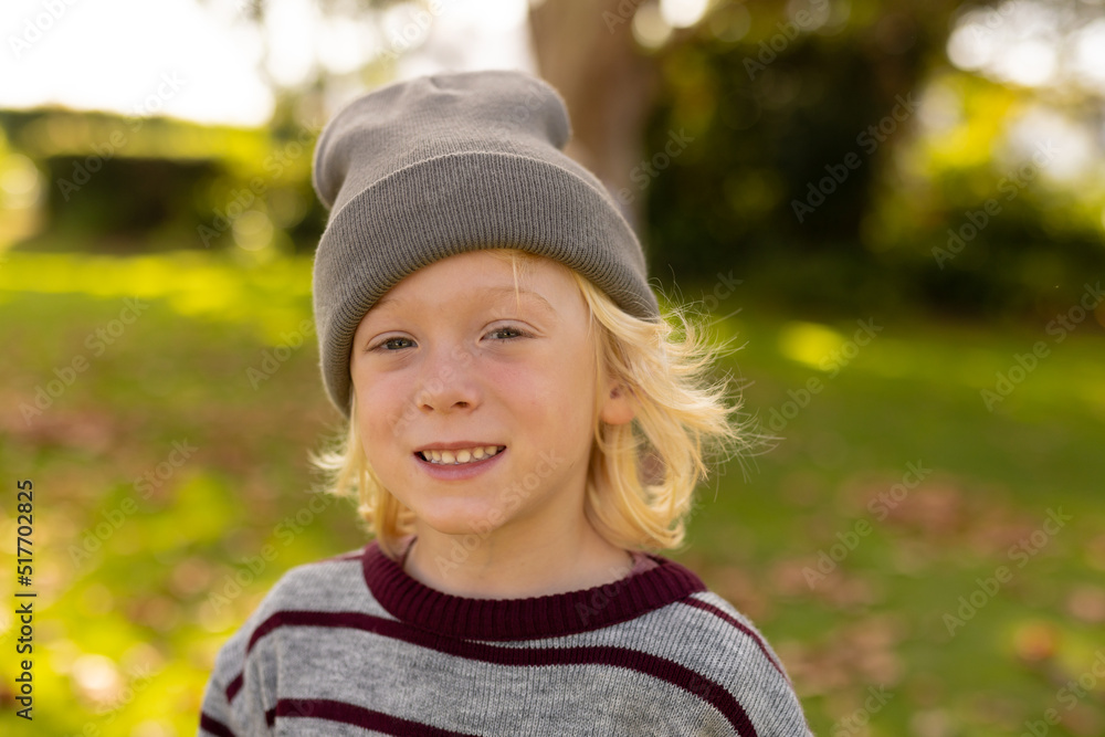 Image of happy caucasian boy smiling at camera in garden Image of happy caucasian boy smiling at camera in garden