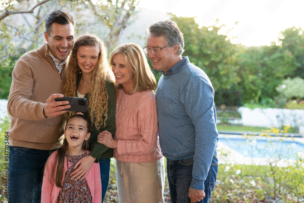 Image of happy multi generation caucasian family taking selfie after dinner on patio