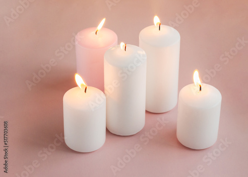 Set of burning white and pink wax candles