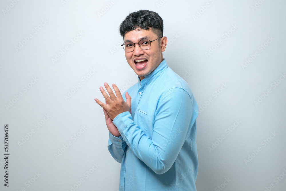 Young handsome man clapping and applauding happy and joyful, smiling proud hands together Young handsome man clapping and applauding happy and joyful, smiling proud hands together