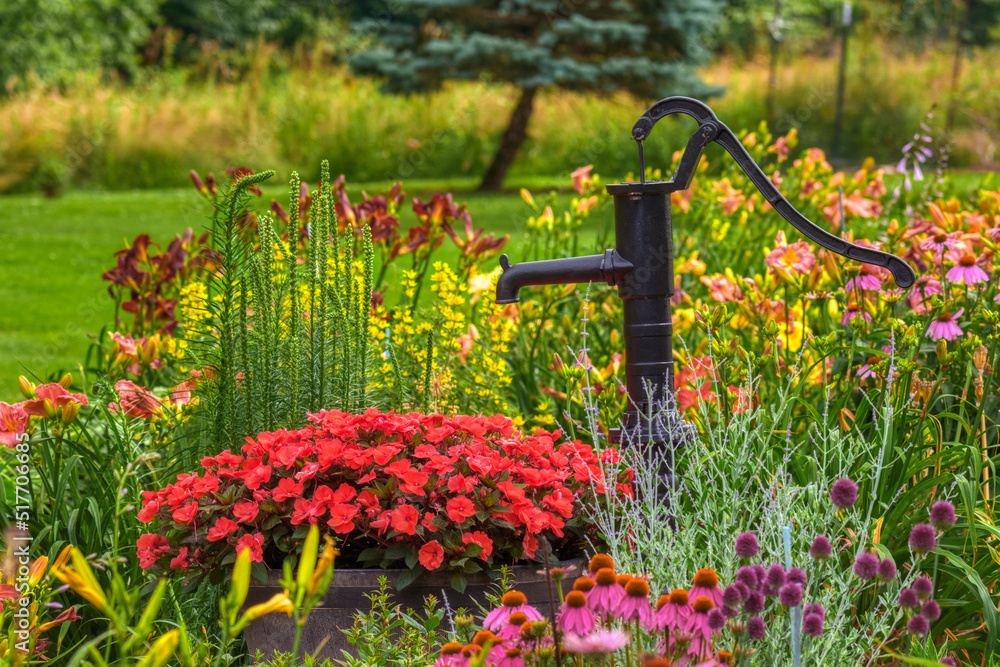 A hand water pump is in the middle of this beautiful home garden in PA