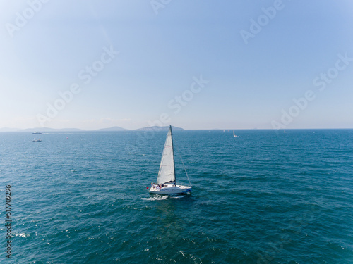 Aerial view of sailing ship yacht with white sails at deep open sea.  © ern