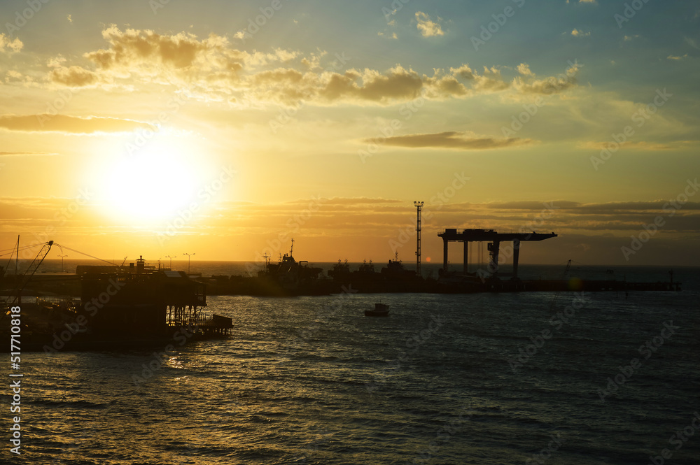 a sea pier at sunset, a beautiful summer horizon. the port is in the city. background for the design.