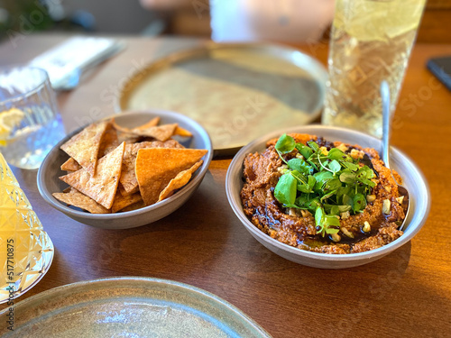 Muhammara, healthy walnut and roasted red bell pepper dip served with tortilla chips served at restaurant.