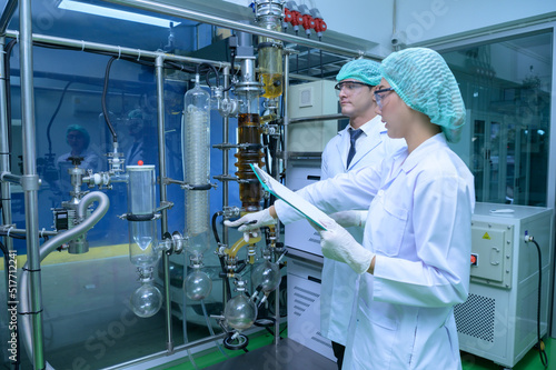 Scientists and assistants are in the machine room extracting oil and cannabis seeds. Inspecting cannabis oil extractor before starting to extract the prepared cannabis