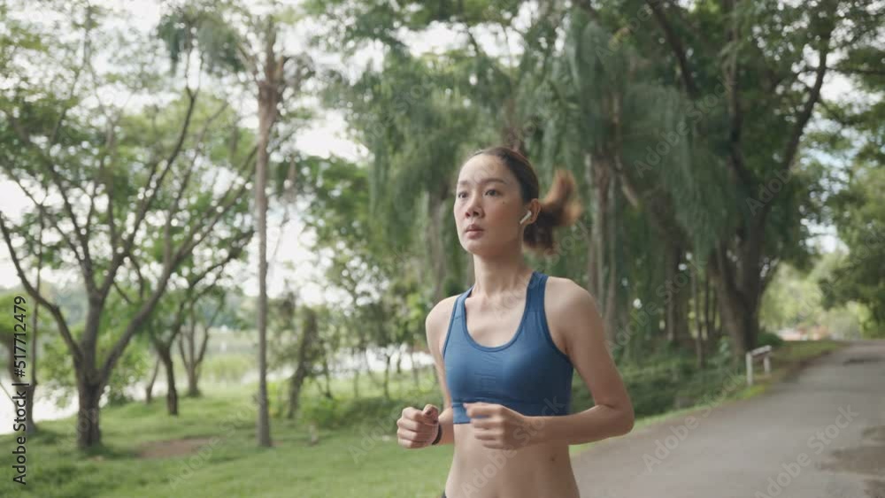 Young Asian women are exercising with outdoor running with a mountain and lake background in the morning. Concept healthy running and outdoor exercise,Tracking shot, 4k resolution. Young Asian women are exercising with outdoor running with a mountain and lake background in the morning. Concept healthy running and outdoor exercise,Tracking shot, 4k resolution.