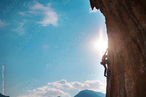 Rock climber on the background of high mountains and blue sky